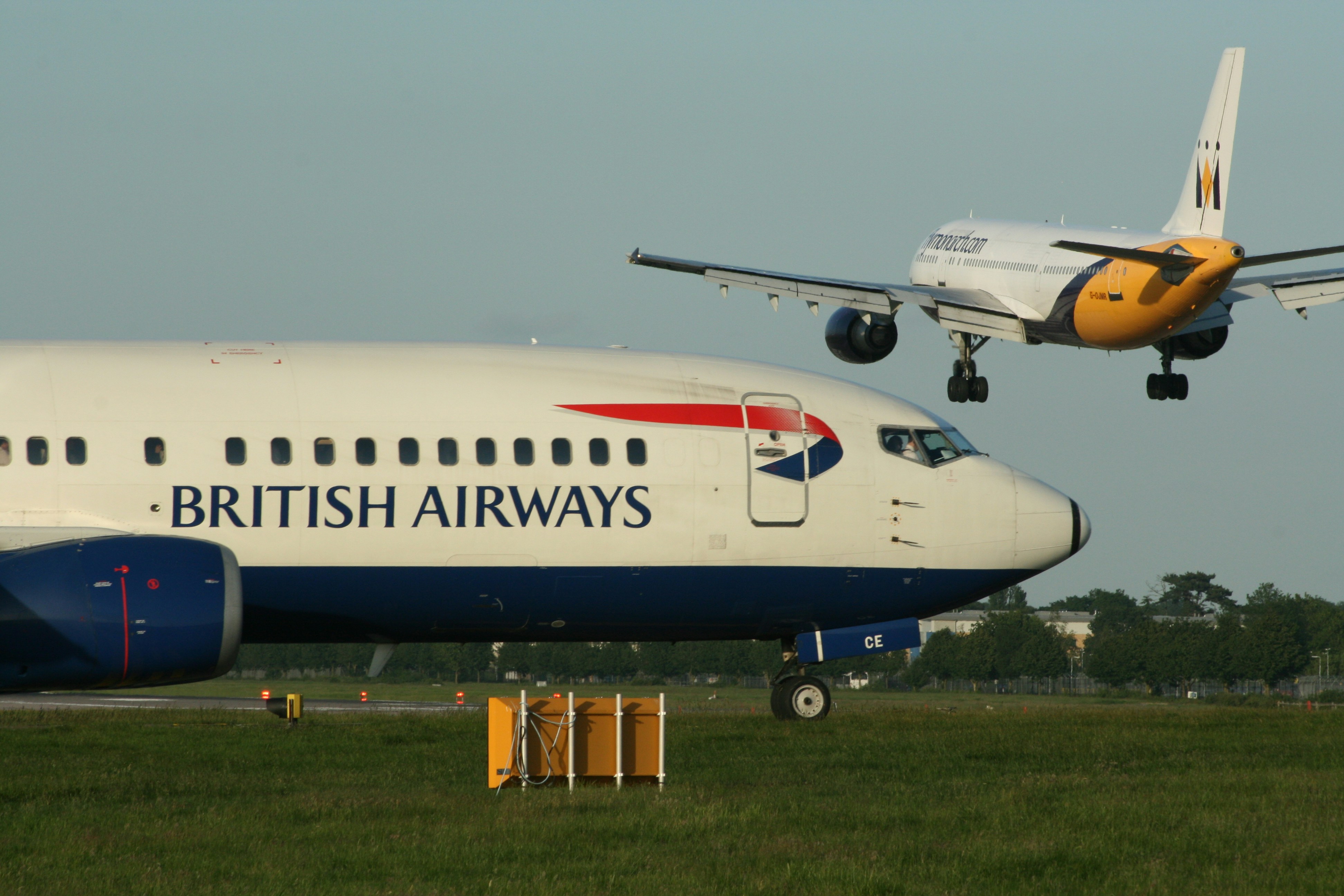 View from airport terminal window of a British Airways plane taxiing on the runway.